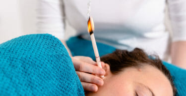 Das Flackern der Kerze massiert das Trommelfell während der Ohrenkerzenbehandlung.